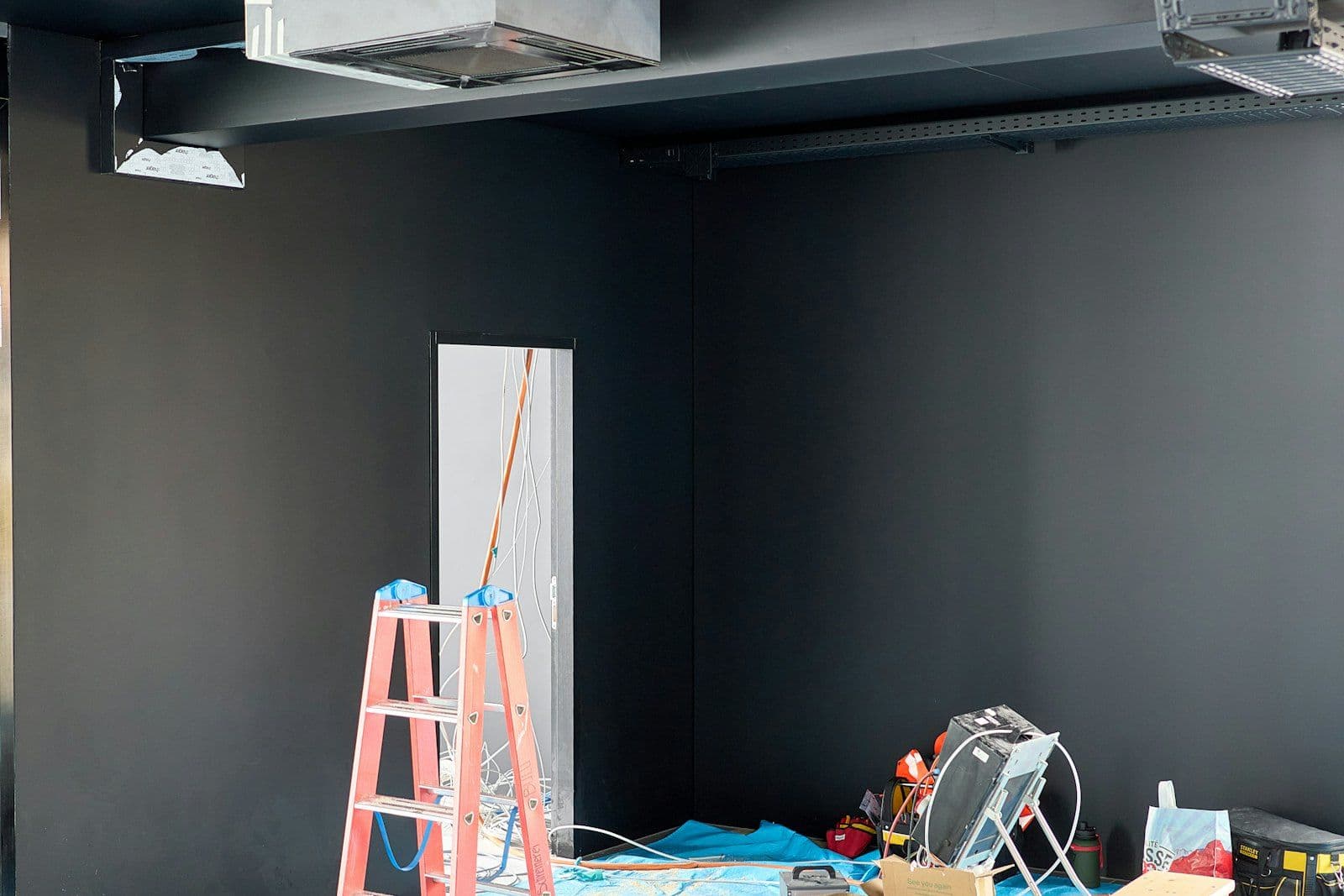 Office build-out with ladders and tools before final post-construction clean